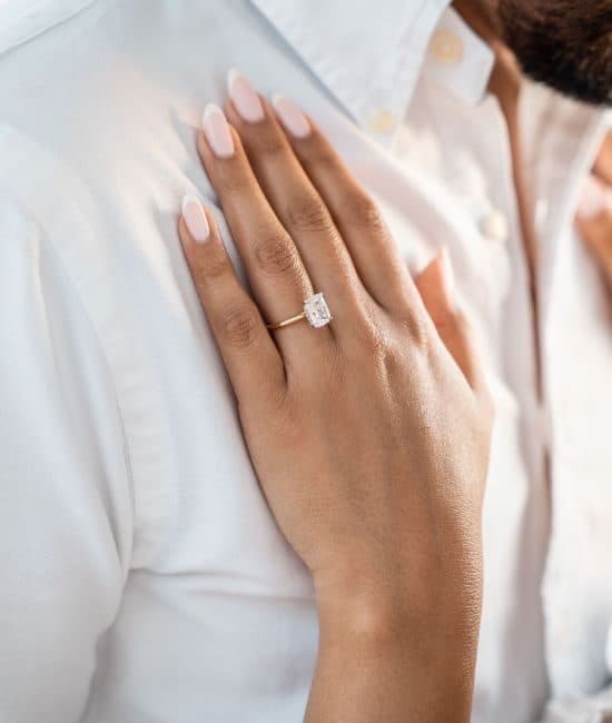 Oval diamond solitaire engagement ring, worn on the hand